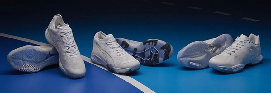 Trei perechi de pantofi de handbal Puma pe un teren de handbal albastru